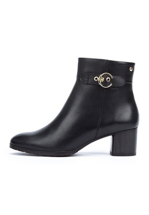 Black leather ankle boot with a rounded toe, a chunky heel, and a gold circular accent on the side. Smooth texture with minimal detailing.