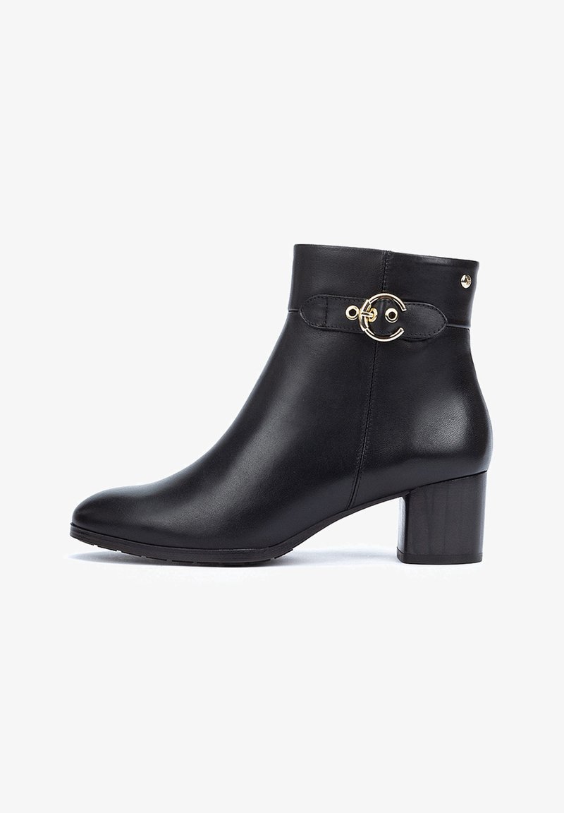 Black leather ankle boot with a rounded toe, a chunky heel, and a gold circular accent on the side. Smooth texture with minimal detailing.