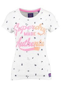 Camiseta de algodón blanca con un estampado gráfico colorido que incluye el texto "Superdry Made Authentic", una piña y formas geométricas en negro.