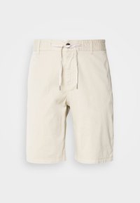 Shorts beige clair en coton, avec une ceinture à cordon de serrage aux bouts argentés, texture lisse et coupe droite.