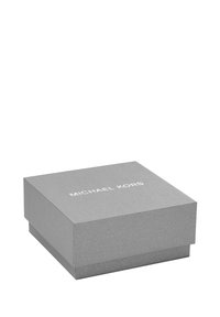 Caja de regalo rectangular gris con una superficie texturizada, que presenta el logo blanco "MICHAEL KORS" en la parte superior. Cerrada, sin objetos visibles en su interior.