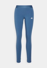 Blå stretchiga tights med en slät textur, med en bred midja och vita sidostrikar. Logotypen visas på lårets övre del.