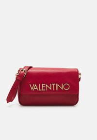 Borsa a tracolla rossa in pelle con patta pieghevole, scritta dorata "VALENTINO", tracolla regolabile e superficie liscia.