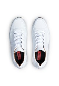 Hvide sneakers med en glat læderoverdel, hvide snørebånd, sort indvendig foring og rød branding på indersålerne. Rund tå og gummisål.