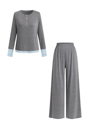 Chemise grise à manches longues avec détails en dentelle et patte de boutonnage, associée à un pantalon gris ample avec ceinture élastique.