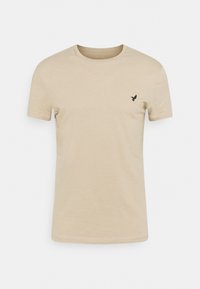Beige cotton t-shirt with a round neck, short sleeves, and a small black bird logo on the left chest. Soft texture, classic fit.