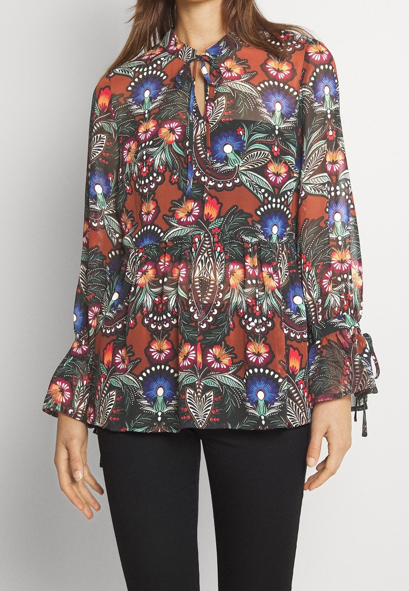 Hnědá květinová blůza s nafouknutými rukávy, výstřihem ve tvaru klíče a nařaseným pasem. Obsahuje barevné vzory květin a listů v modré, červené a zelené barvě.