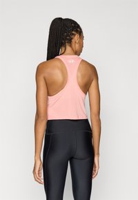 Top desportivo rosa cropped com textura em malha e design de costas nadador, combinado com leggings pretas de cintura alta.