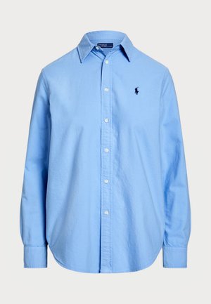 Šviesiai mėlynas ilgomis rankovėmis mygtuku užsegamas marškinis su klasikinio stiliaus apykaklė, turintis vieną siuvinėtą logotipą. Pagamintas iš medvilnės su sklandžiu paviršiumi.