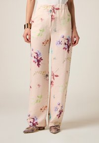 Pantaloni in tessuto arricciato con fantasia floreale in morbido pesca, con accenti verdi, viola e rosa. Vita elastica; silhouette a gamba larga.