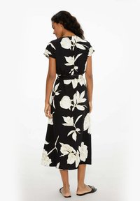 Čierna maxi šaty s kvetinovým vzorom a krátkymi rukávmi, biele ružové vzory, opasok v páse a splývavá sukňa. Hladká tkanina a stredná dĺžka.