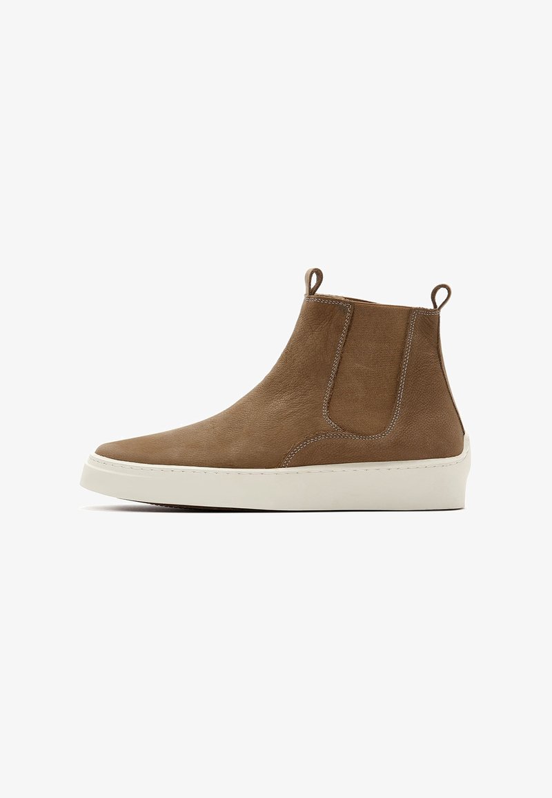 Bottine en cuir marron avec panneaux latéraux élastiques, talon renforcé, semelle en caoutchouc blanche et détails de couture blanche contrastants.