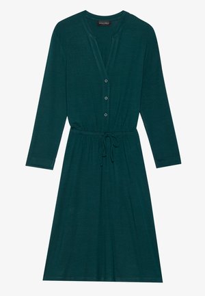 Mēteļa krāsas kleita ar garām piedurknēm, V veida izgriezumu un pogu aizdari. Tam ir regulējama jostas vieta un brīvs piegriezums, izgatavota no mīksta auduma.