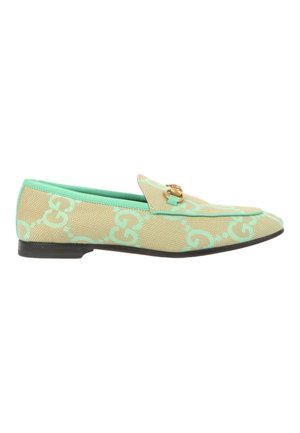 Mocassin beige et vert menthe à motif avec un détail mors doré et une semelle noire, vue de côté sur fond blanc.