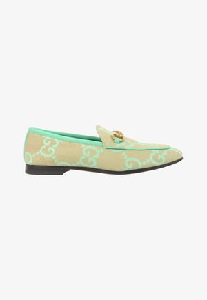 Mocassin beige et vert menthe à motif avec un détail mors doré et une semelle noire, vue de côté sur fond blanc.