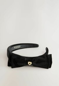 Fascia in velluto nero con un'accenno a fiocco annodato e un piccolo cuore dorato al centro. Design testurizzato con una banda interna liscia.