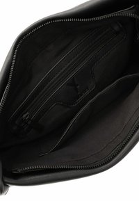 Interno della borsa in pelle nera caratterizzato da una texture liscia, una tasca con zip e un ampio scomparto foderato in tessuto.