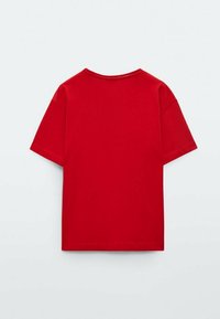 T-shirt rouge à manches courtes en coton. Design simple avec un col rond et un ourlet droit. Texture lisse, sans motifs ni accents visibles.