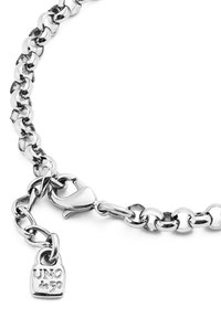 Pulsera de cadena de plata con eslabones entrelazados, un cierre de langosta y un pequeño charm en forma de candado con "UNO de 50" grabado.