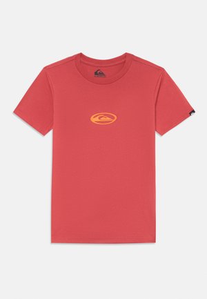 Red cotton t-shirt with a crew neck, featuring a yellow circular logo on the chest and a small black label on the sleeve. Short sleeves.