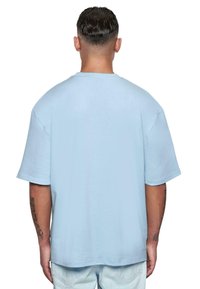 Lysblå oversized bomulds t-shirt med korte ærmer, rund halsudskæring og en glat tekstur. Viser ingen grafiske eller mønsterdetaljer.