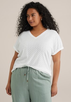 White V-neck T-shirt with a textured herringbone pattern, paired with loose, light green pants featuring a drawstring and bead accents.
