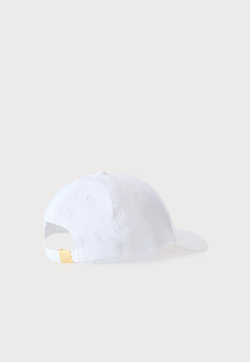 Casquette de baseball blanche avec sangle réglable et boucle dorée sur un fond gris clair uni, vue de dos.