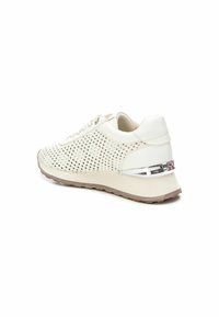 Zapatilla blanca perforada con un upper texturizado, suela de un color beige claro y acento plateado en el talón. Cuenta con un sistema de cordones tradicional y una punta redonda.