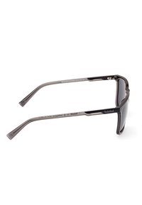 Ochelari de soare Timberland pentru bărbați cu lentile întunecate polarizate, cadru metalic negru elegant și tempere curbate pentru o fixare sigură.