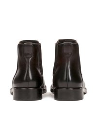 Bocanci Chelsea din piele neagră cu o textură netedă, vârful rotunjit și curele la spate. Tălpile din cauciuc robuste oferă aderență și durabilitate.