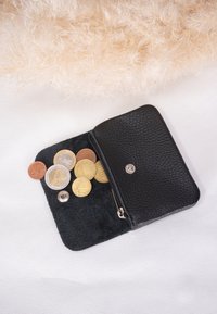 Schwarze Ledergeldbörse mit Reißverschluss, die eine Vielzahl von Münzen im Inneren zeigt. Strukturierten Oberfläche, abgerundete Ecken, silberne Hardware-Akzente.