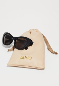 Ochelari de soare negri tip cat-eye cu lentile degradate, însoțiți de un săculeț bej cu șnur, având inscripția aurie "LIU·JO".