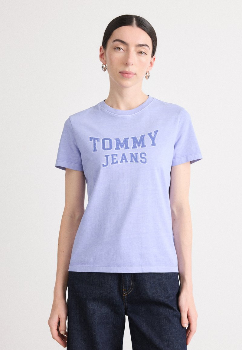 Heledad lilla puuvillane T-särk lühikeste varukatega. Rinnal on kontrastsete tumehallide tähtedega "TOMMY JEANS" logo. Lihtne, klassikaline disain.