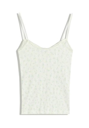 White ribbed camisole with thin straps, featuring small blue and green floral print throughout and lace trim along the neckline.