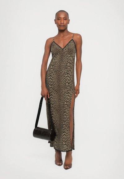 Abito lungo con stampa leopardo e spalline sottili, caratterizzato da una profonda scollatura a V e spacchi laterali. Abbinato a una borsa cilindrica nera.