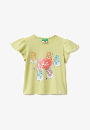 Jasnozielona koszulka z krótkim rękawem i falbankami na rękawach, z kolorowymi Pluszakami z opieki siedzącymi na chmurach wokół czerwonego serca z napisem "Care Bears".