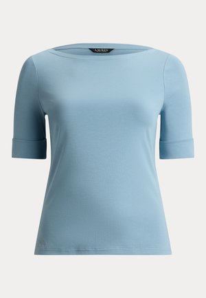 Világoskék rövid ujjú női felső hajónyakkivágással és mandzsettás ujjal, sima anyagból, fehér háttéren laposan elhelyezve.