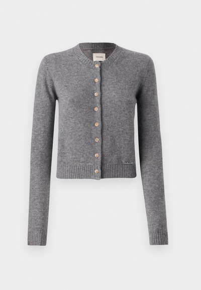 Pelēks džemperis, izgatavots no mīkstas adītas materiāla, ar apaļu kakla izgriezumu, garām piedurknēm un koka pogām priekšpusē. Ribota apakšdaļa un piedurkņu gali.