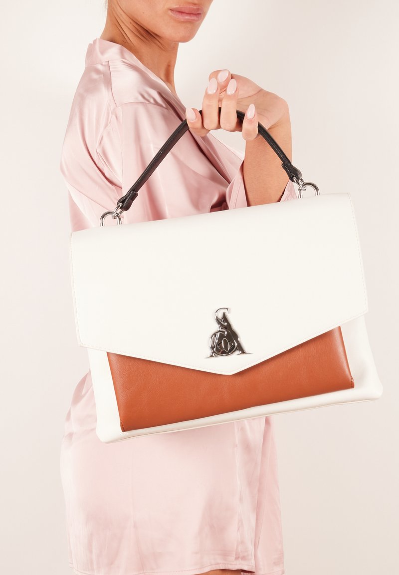 Biała i brązowa skórzana torebka z klapą, z srebrnym akcentem z logo i czarnym uchwytem. Gładka faktura, wyraźny kształt.