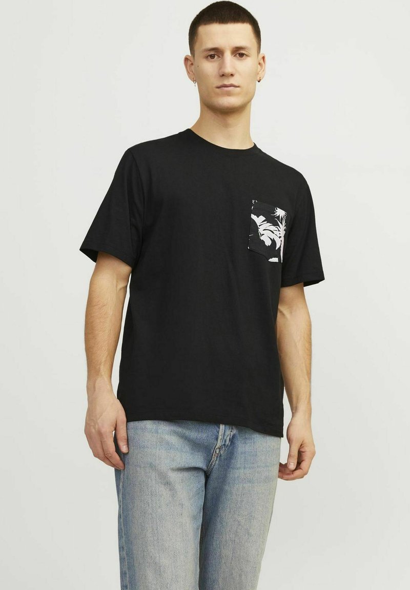 Sort bomulds t-shirt med rund halsudskæring og korte ærmer, med et hvidt palmebladsmønster på venstre brystlomme.