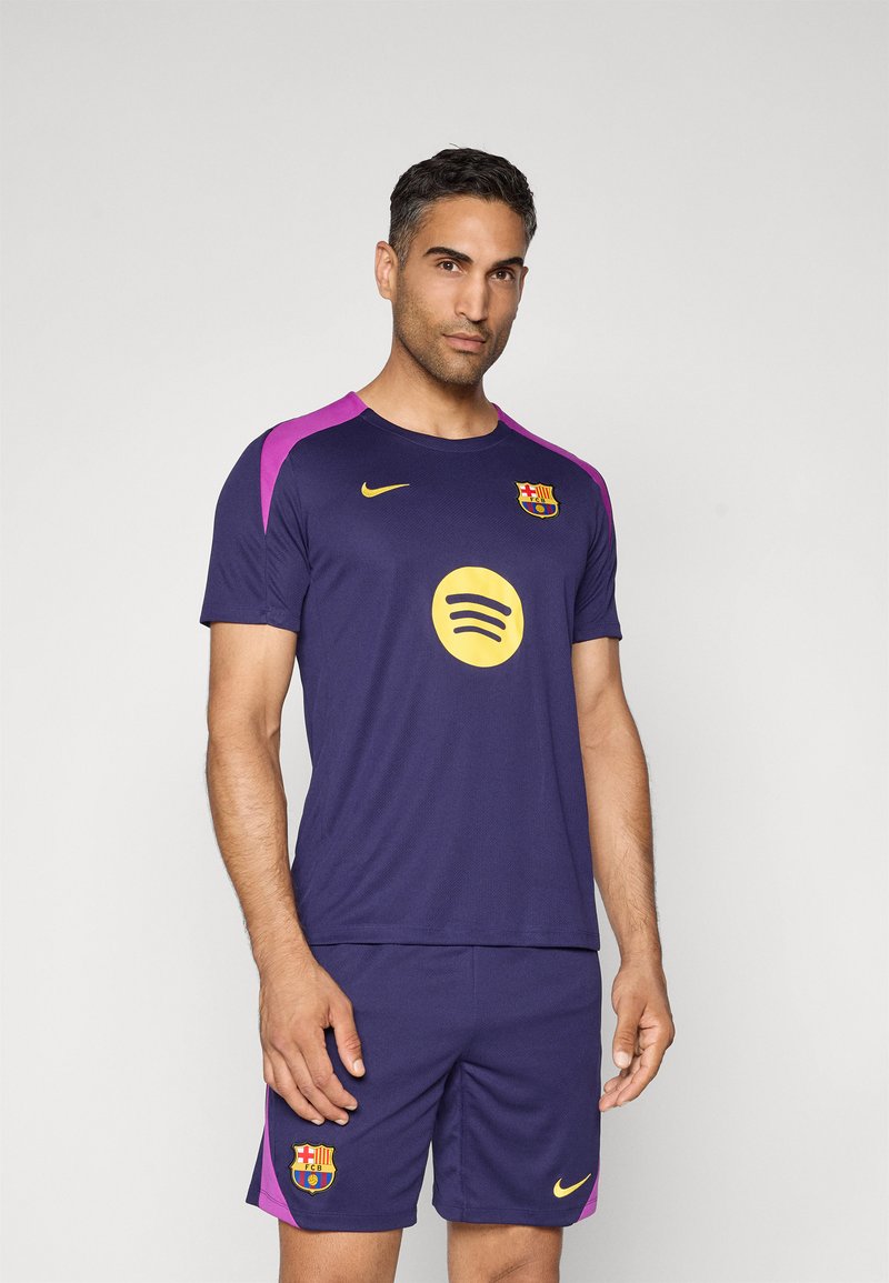 Navy blue football kit with purple accents, featuring a round yellow Spotify logo and a Barcelona crest. Made from lightweight fabric with short sleeves.