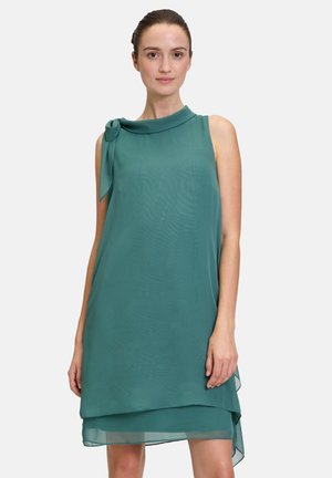 Türkises ärmelloses Kleid aus leichtem, fließendem Stoff mit einem drapierten Design, das eine Schleifenakzent am Ausschnitt und einen geschichteten Saum aufweist.