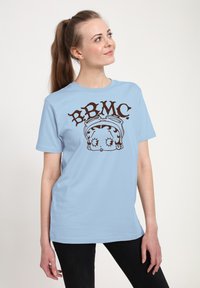 Hellblaue Baumwoll-T-Shirt mit einem braunen Grafikdesign, auf dem die Buchstaben "BBMC" und das Gesicht eines Cartoon-Charakters abgebildet sind. Kurze Ärmel, lockere Passform.