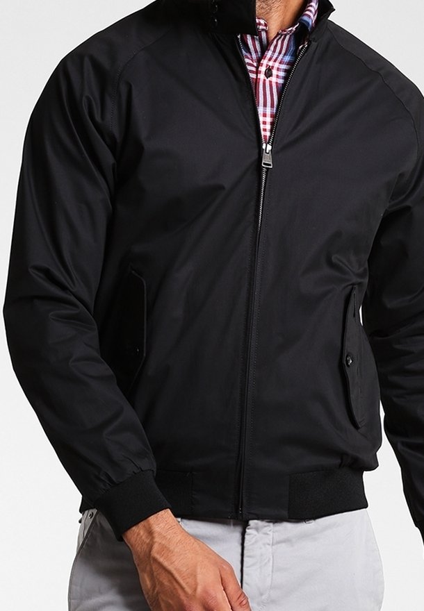 Giubbotto bomber nero con zip frontale, polsini a coste e due tasche laterali. Presenta una superficie liscia e una silhouette classica.