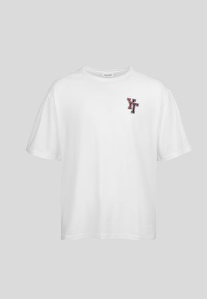 Balta kokvilnas T-krekls ar īsām piedurknēm, apaļu kakla izgriezumu un mazu daudzkrāsainu izšūtu "YT" logotipu kreisajā krūtī.