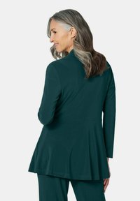 Teal, lange mouwen tuniek met een uitlopende zoom en een soepele textuur, voorzien van een klassieke kraag en een getailleerde pasvorm.