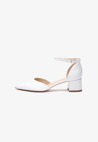 Zapatos de tacón ancho de cuero blanco con punta puntiaguda, correa en el tobillo y diseño con recortes. Textura suave con forro interior beige.