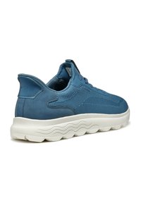 Sneaker blu con una parte superiore testurizzata e accenti in suede liscio. Suola bianca spessa con motivo a onda. Design con lacci e supporto rinforzato per il tallone.