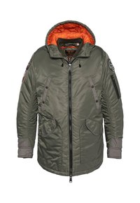 Zielona, ocieplana kurtka z pomarańczowym, pikowanym wykończeniem, zamek błyskawiczny, dwie przednie kieszenie i kieszeń na rękawie. Posiada ściągacze przy mankietach oraz naszywki.