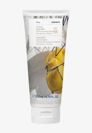 Tubka mleczka do ciała Korres o zapachu cytrusów z olejem migdałowym, 200 ml, z grafiką cytryn na opakowaniu.